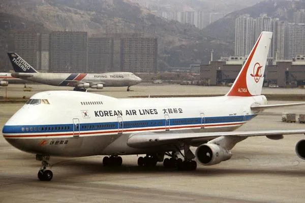 Airplane on airport tarmac with mountains in background